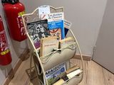 a fire extinguisor next to a magazine rack on the floor