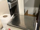 une balance posée sur une table, à côté d'un rouleau de papier toilette
