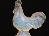 the figurine of a rooster is sitting on top of a table