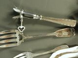 a lot of silver spoons and forks on a table