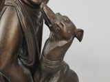 bronze statue of a woman with a dog on a white background