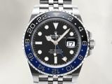 a close up of a wrist watch with a black dial and blue bezel