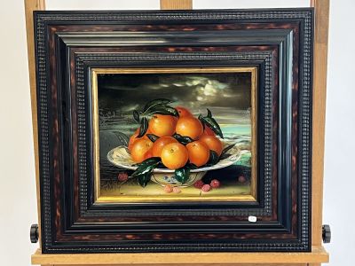 a painting of oranges on a plate on a easel