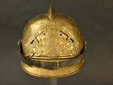a gold helmet with a crest on it on a stand