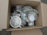 a cardboard box filled with a bunch of plates and cups