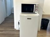 un petit réfrigérateur blanc surmonté d'un micro-ondes
