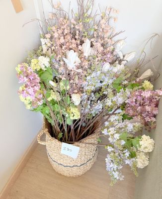 un panier de fleurs posé sur une étagère près d'un mur