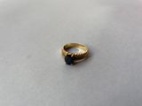 une image d'une bague en or avec une pierre bleue