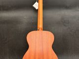 an acoustic guitar sitting on a stand against a wall