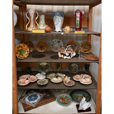 de nombreuses assiettes et vases sur les étagères de ce buffet
