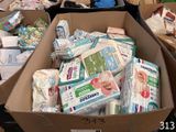 Des boîtes de couches et de lingettes sont empilées sur un carton