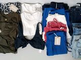 Plusieurs paires de jeans sont disposées sur une surface blanche