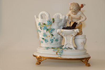 une figurine représentant une femme avec un chat posée sur une table