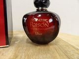 christian dior perfume bottle sitting on a wooden table next to a red box