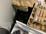 un écran d'ordinateur posé sur un bureau, à côté d'une pile de cartons