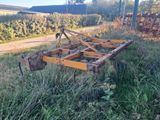 a tractor that is sitting in the grass by the road