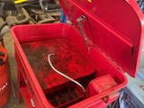 une boîte à outils rouge, ouverte, posée dans un garage