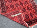 an image of a red rug laying on the ground with a tag on it