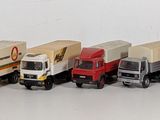 several toy trucks are lined up in a row on a white surface