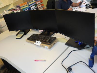 un homme assis à un bureau sur lequel se trouvent deux écrans d'ordinateur
