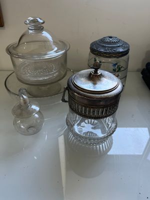 de nombreux bocaux en verre posés sur une table, avec un miroir en arrière-plan