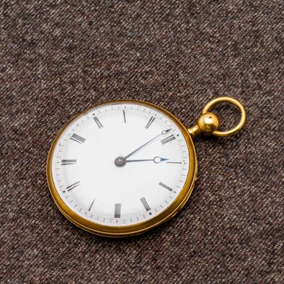 une montre de poche en or avec des chiffres romains