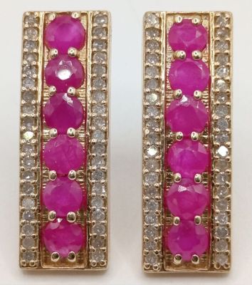 a pair of pink and white stone earrings on a white surface