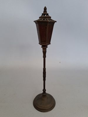 une petite lampe posée sur un pied, sur une table