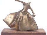bronze sculpture of a woman in a flowing dress on a wooden base