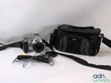 a camera and a bag on a white surface