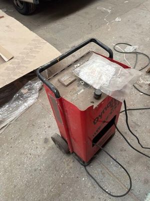 a small red machine that is sitting on the ground