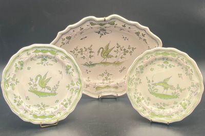 three green and white plates with birds on them on a table