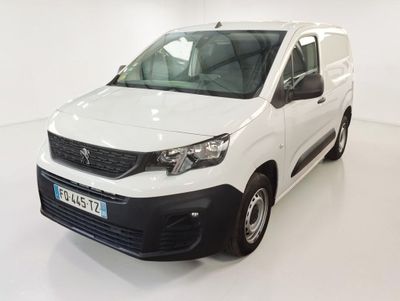 La camionnette blanche est garée dans une pièce blanche au sol blanc.
