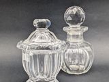 deux bocaux en verre transparent avec leurs couvercles, posés sur une surface noire