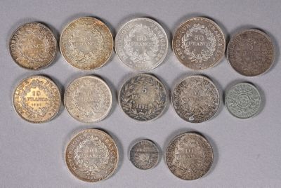 plusieurs types de pièces de monnaie sont disposés sur une surface blanche