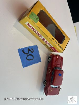 une petite voiture rouge posée à côté d'une boîte jaune