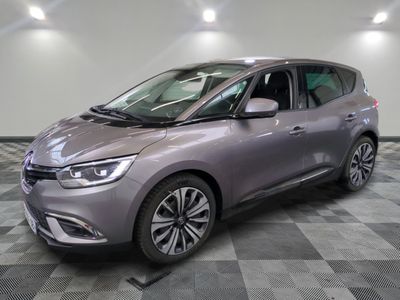 the grey car is parked on a checkered floor in the garage