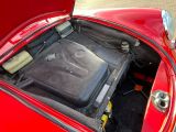 une voiture rouge dont le capot est ouvert et le moteur se trouve dans le coffre