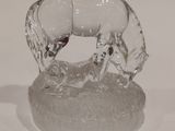 une figurine en verre représentant un cheval posée sur un socle