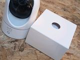 a white box with a black camera on it and a white box with a black camera on top of it