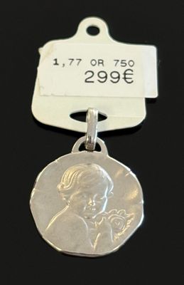 un gros plan d'une médaille d'argent à laquelle est attachée une étiquette