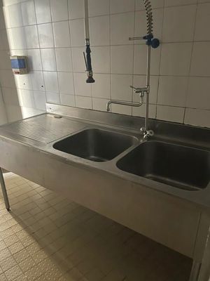 deux éviers dans la cuisine, avec un robinet et un mitigeur mural