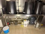 a kitchen with a lot of pots and buckets on the counter