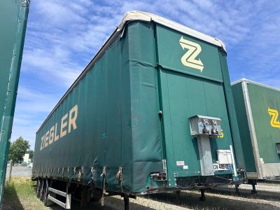 un gros camion vert garé sur le bord de la route