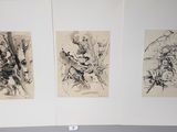 three paintings on the wall of a room with a bed