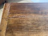 a close up of a wooden table with a tile floor