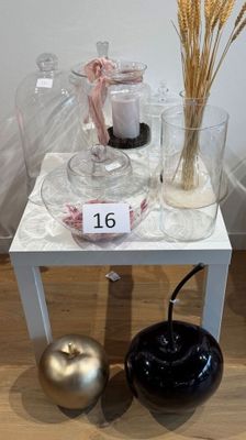 une petite table sur laquelle se trouvent un vase et une bougie