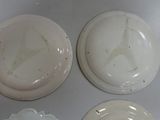 three white plates with a design on them are sitting on a table