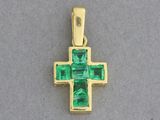 une image représentant un pendentif en forme de croix en or orné d'émeraudes