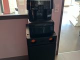 a coffee machine on top of a refrigerator in a room